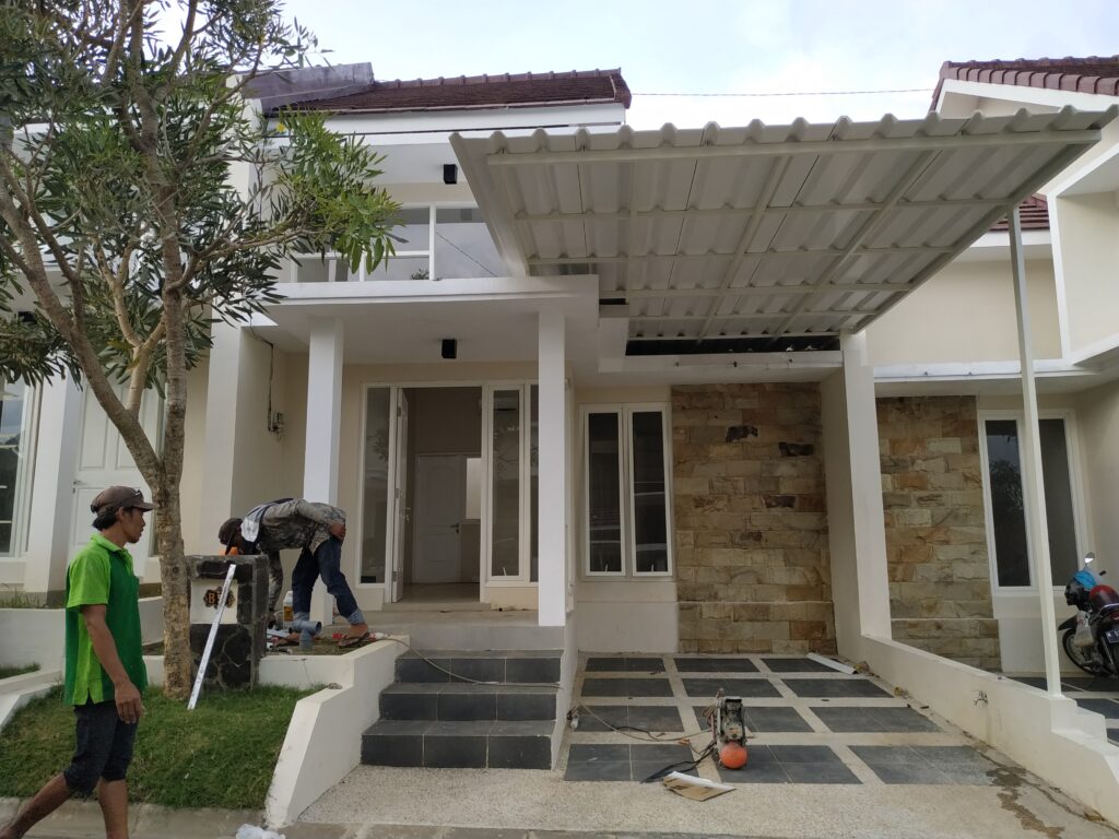 Tukang sedang melakukan jasa pasang kanopi atap Alderon di rumah minimalis area Malang dan Batu